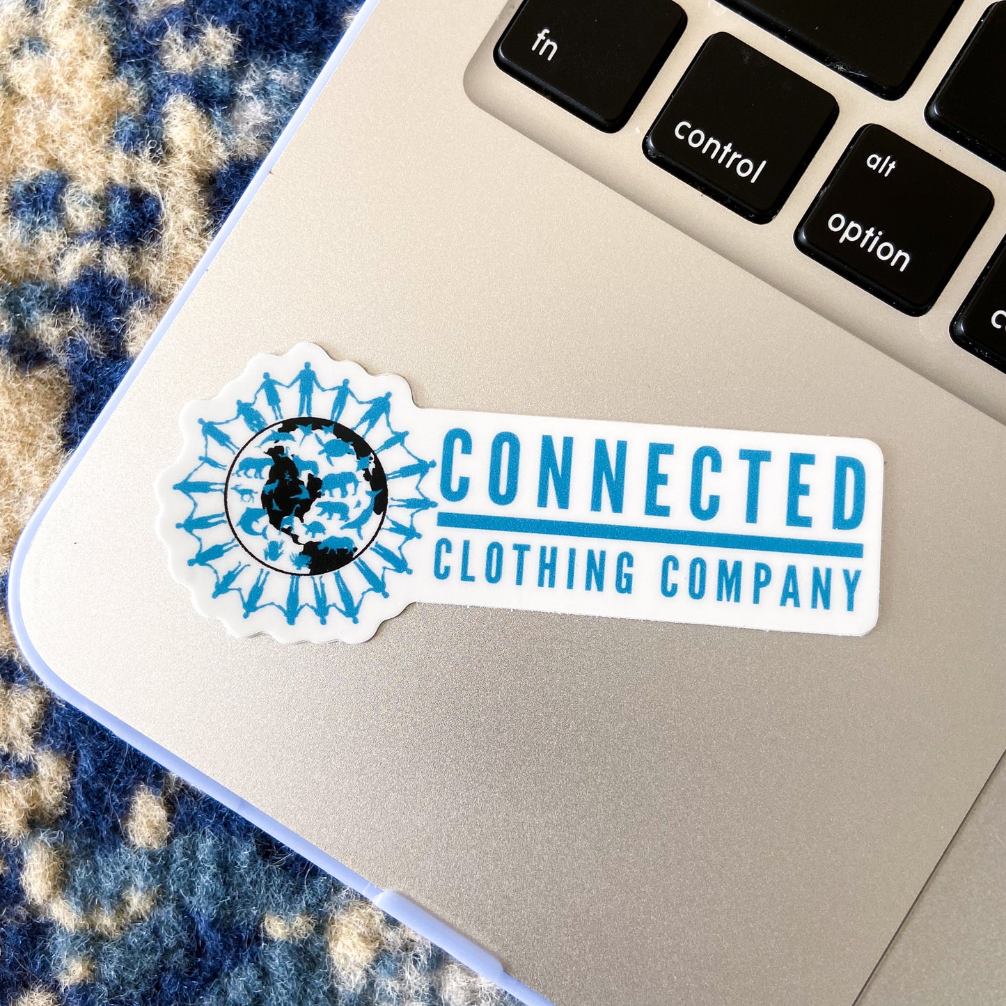 Connected Clothing Company Logo Sticker on a Macbook for size reference.