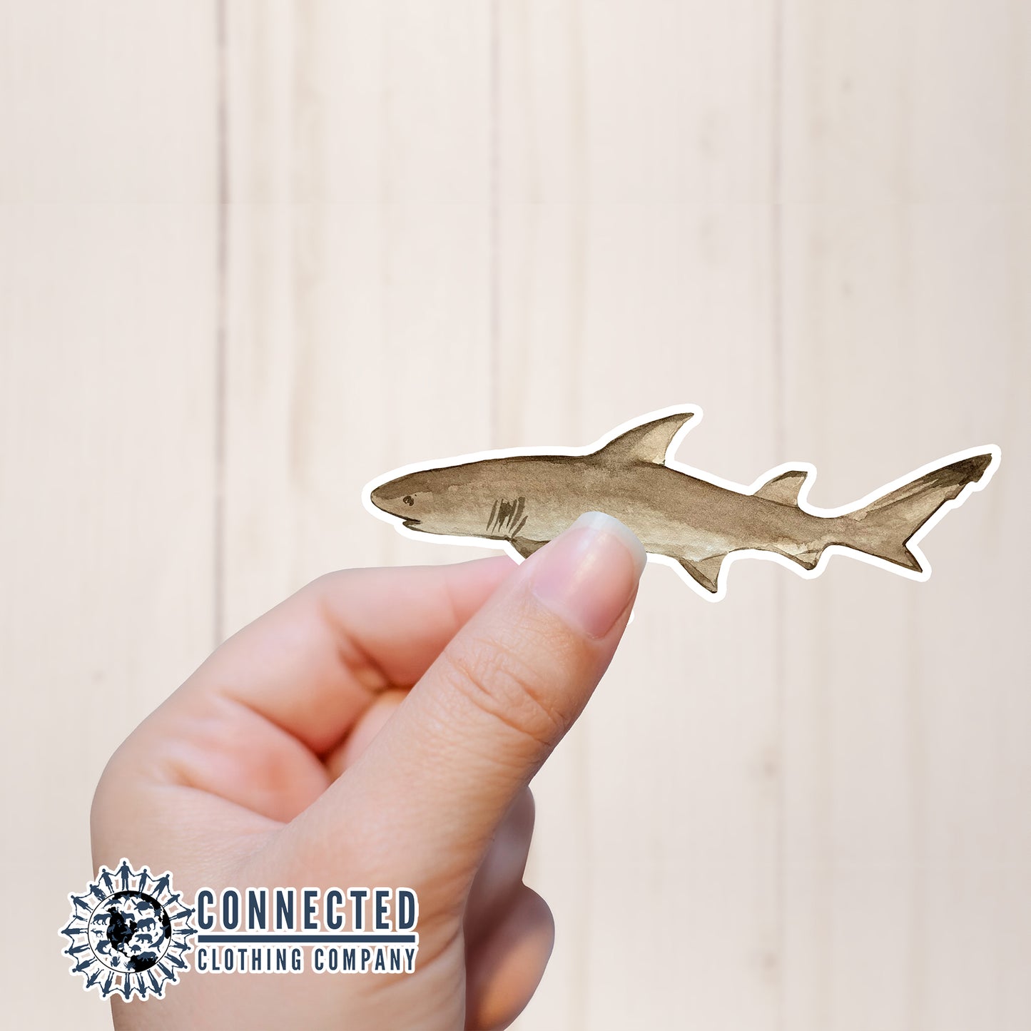 Hand Holding Lemon Shark Watercolor Sticker - Connected Clothing Company - Ethical and Sustainable Apparel - portion of profits donated to shark conservation